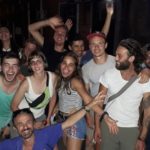 Групка щасливих учасників, які сміються, дехто махає рукою на камеру.